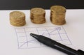Sales and financial business graph - hand drawn with ball pen on white paper and piles of golden money coins showing profits and g Royalty Free Stock Photo