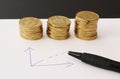 Sales and financial business graph - hand drawn with ball pen on white paper and piles of golden money coins showing profits and g Royalty Free Stock Photo