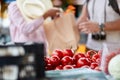 Sales of fresh and organic tomatos at the green market or farmers market.  Buyers choose and buy products for healthy food in Royalty Free Stock Photo