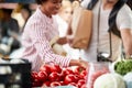 Sales of fresh and organic tomatos at the green market or farmers market.  Buyers choose and buy products for healthy food in Royalty Free Stock Photo