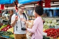 Sales of fresh and organic vegetables and  fruits at the green market or farmers market.  Buyers choose and buy products for Royalty Free Stock Photo
