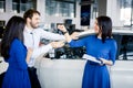 Happy young couple getting keys of their new car at dealership Royalty Free Stock Photo