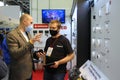 Sales manager consulting customer standing in front of a stand with sensors detectors for smart house systems