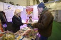 Sales manager giving man books, magazines and books about gardening placed on a stand.