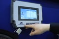 Sales manager touching control panel of a feed transportation system, used in animal husbandry