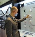 Sales manager touching sensor detector for smart house systems standing in front of a stand with sensors detectors