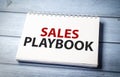 sales playbook text on paper on the wooden background