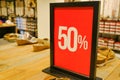 50 sales sign card in clothes store close-up across shelves with shoes and sneakers. Sales, discount, Black Friday, Cyber Monday, Royalty Free Stock Photo