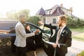 Sales situation in a car dealership outdoors. Young African man gets the key for the new car from Caucasian sales Royalty Free Stock Photo