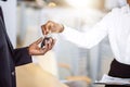 Sales situation in car dealership, young african couple gets the key for new car