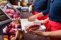 Sales women in butcher shop selling meat and sausages