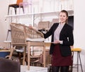 Salesgirl offering wicker loom armchair in salon