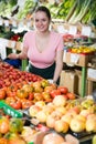Salesgirl proposing fruits and vegetables in supermarket Royalty Free Stock Photo