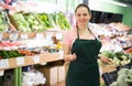 Salesgirl proposing fruits and vegetables in supermarket Royalty Free Stock Photo