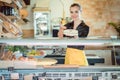 Salesgirl selling cheese in deli or supermarket Royalty Free Stock Photo