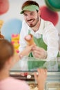 Salesman in confectionery provides ice cream to girl Royalty Free Stock Photo