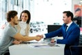 Salesman and customer shaking hands congratulating each other at the dealership showroom Royalty Free Stock Photo