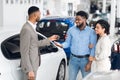 Salesman Giving Car Key To Buyers For Test-Drive In Dealership Royalty Free Stock Photo