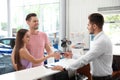 Salesman giving car key to happy couple Royalty Free Stock Photo