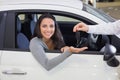 Salesman giving keys to a smiling woman Royalty Free Stock Photo