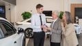 A salesman hands over the keys to a new car to an elderly Caucasian couple. Royalty Free Stock Photo