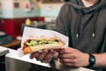 Salesman with hotdog in fast food snack bar