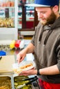 Salesman making hotdog in fast food snack bar