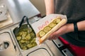 Salesman making hotdog in fast food snack bar