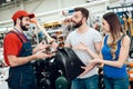 Salesman is showing couple of clients new showel in power tools store. Royalty Free Stock Photo