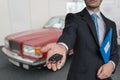 Salesman is selling a new car and passing keys