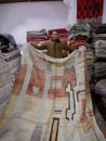 Salesman showing Berber carpet in rug shop in Medina of Marrakech, Morocco, 10.02.2023.