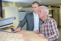 Salesman showing customer velux roof window in showroom