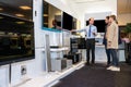 Salesman Showing Flat Screen Tv To Couple In Store