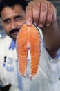 Salesman showing fresh salmon Fish slice, Dubai, United Arab Emirates