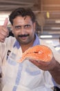 Salesman showing fresh salmon Fish slice, Dubai, United Arab Emirates
