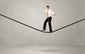 Salesman walking on rope in grey space