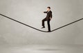 Salesman walking on rope in grey space