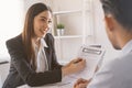 Salesmen are letting the male customers sign the sales contract, Asian women and men are doing business in the office, Business