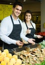 Salespeople with farm mushrooms in market