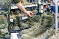 salesperson arranging combat boots on display