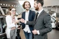 Happy couple buying a new car in the showroom Royalty Free Stock Photo