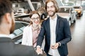 Happy couple buying a new car in the showroom Royalty Free Stock Photo