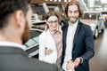 Happy couple buying a new car in the showroom Royalty Free Stock Photo