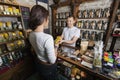 Salesperson giving product to female customer in tea store