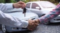 The salesperson held the key and handed it to the customer after the deal was successful. Ideas for renting a car or buying a car