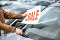 Salesperson putting sale plate on the car Royalty Free Stock Photo