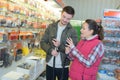 Saleswoman assisting male customer at hardware store