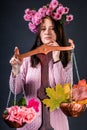 A saleswoman of a beautiful autumn mood weighs flowers and colorful autumn maple leaves on a scales.