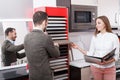 Saleswoman consulting male customer in store of kitchen furnishing