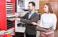 Saleswoman consulting man customer in store of kitchen furnishing